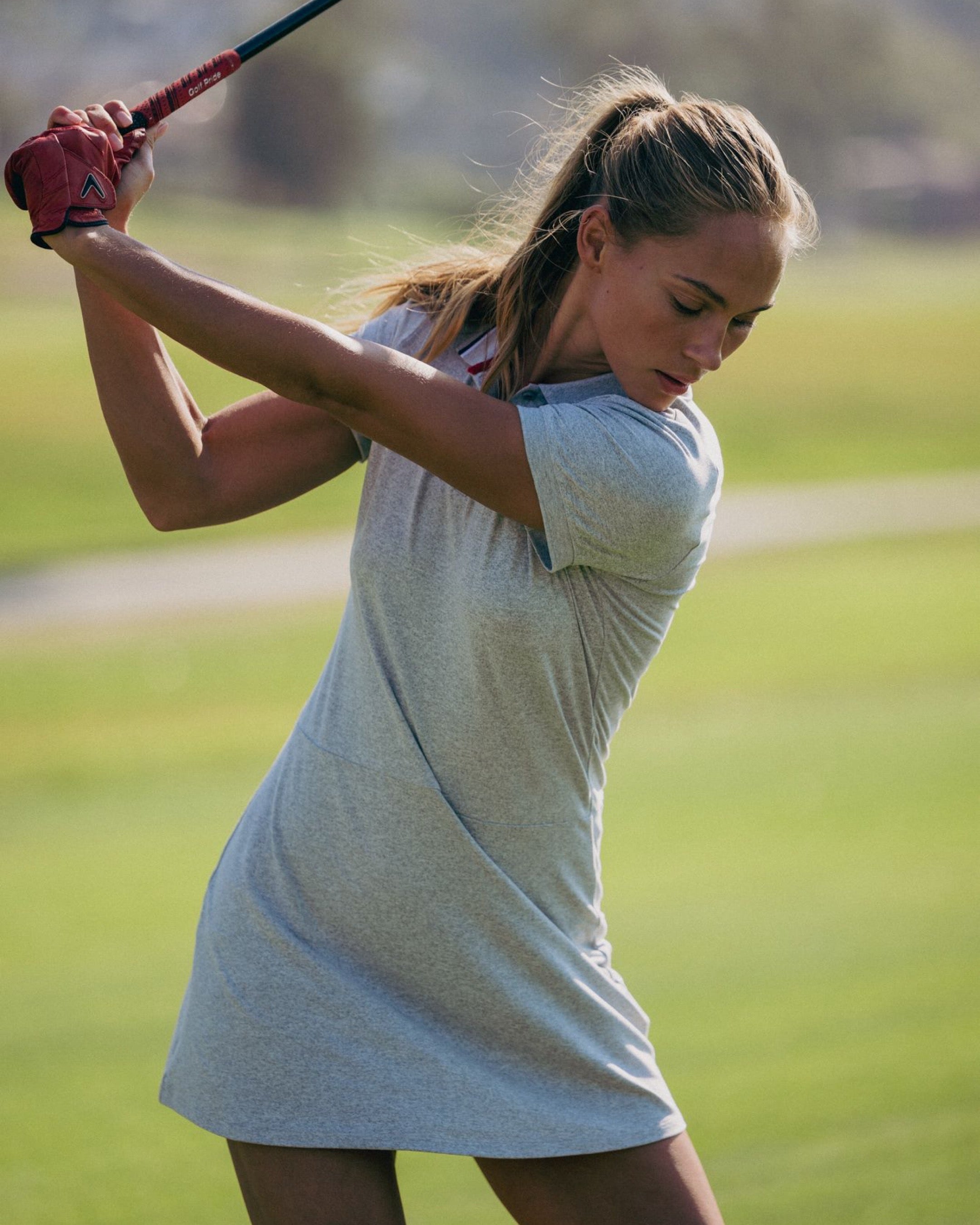 Woman playing golf on a green course