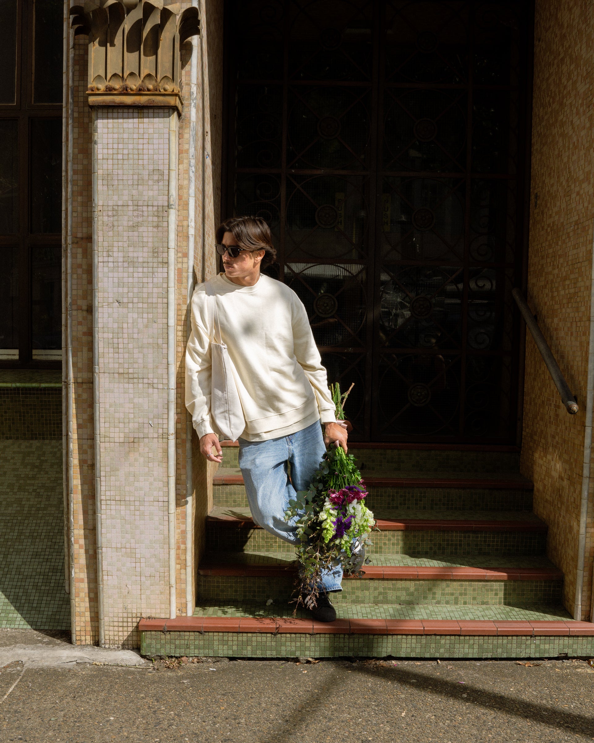 Person exiting a building with a bouquet of flowers
