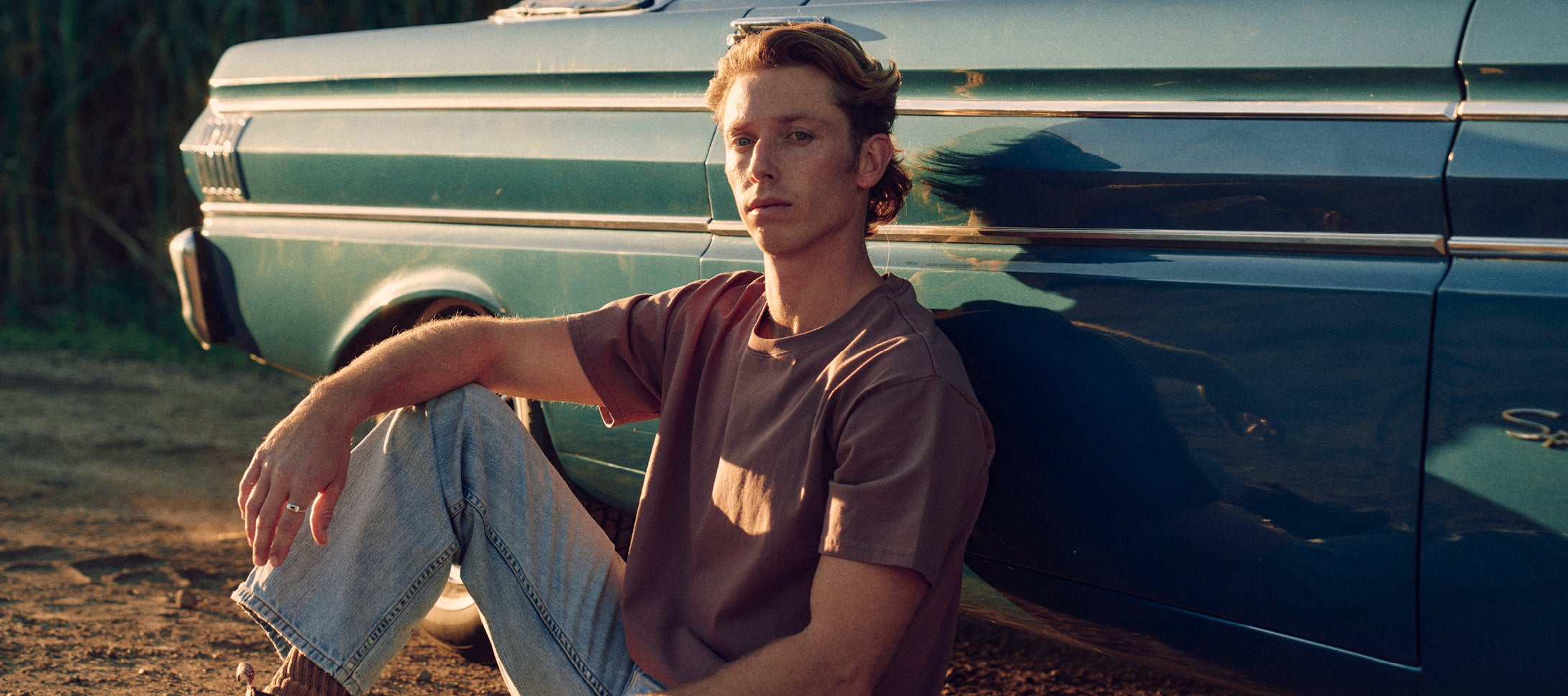 Man sitting infront of a car