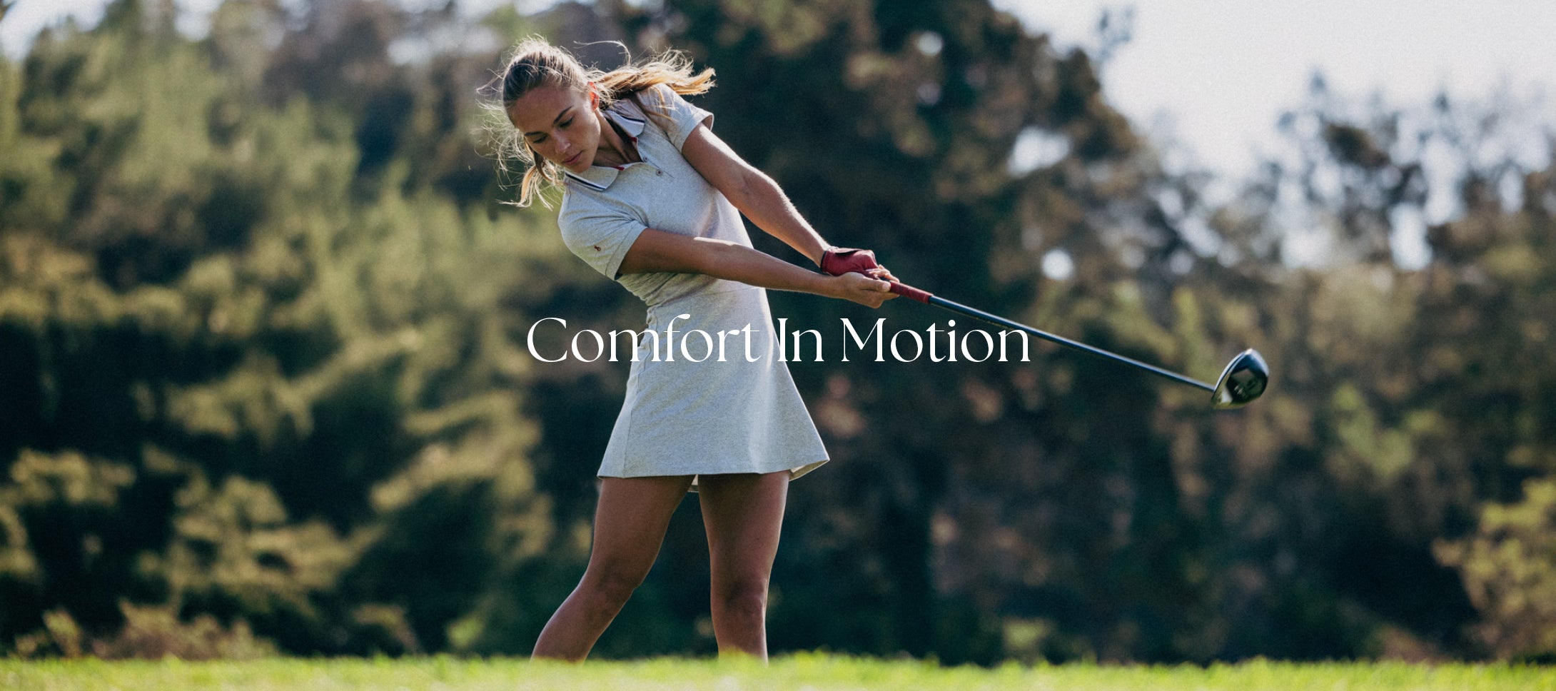 Woman swinging a golf club with the words COMFORT IN MOTION in the middle
