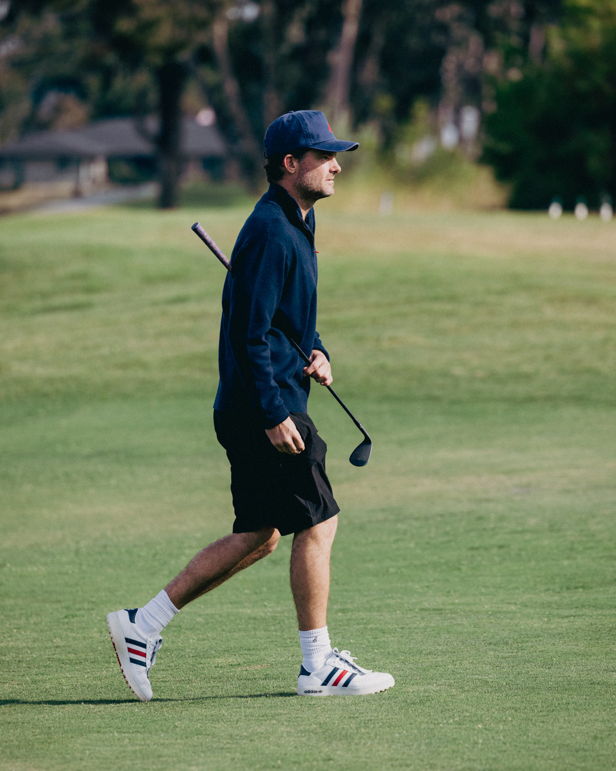 Man walking on a golf course holding a golf club
