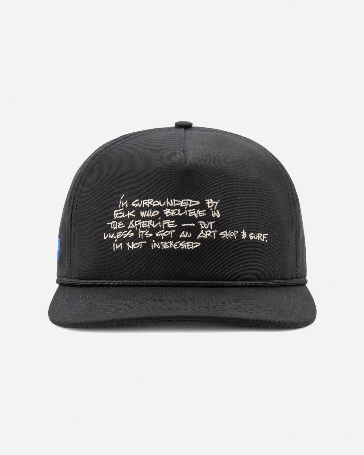A black flat-brim baseball cap with white embroidered text on the front, photographed against a light gray background.