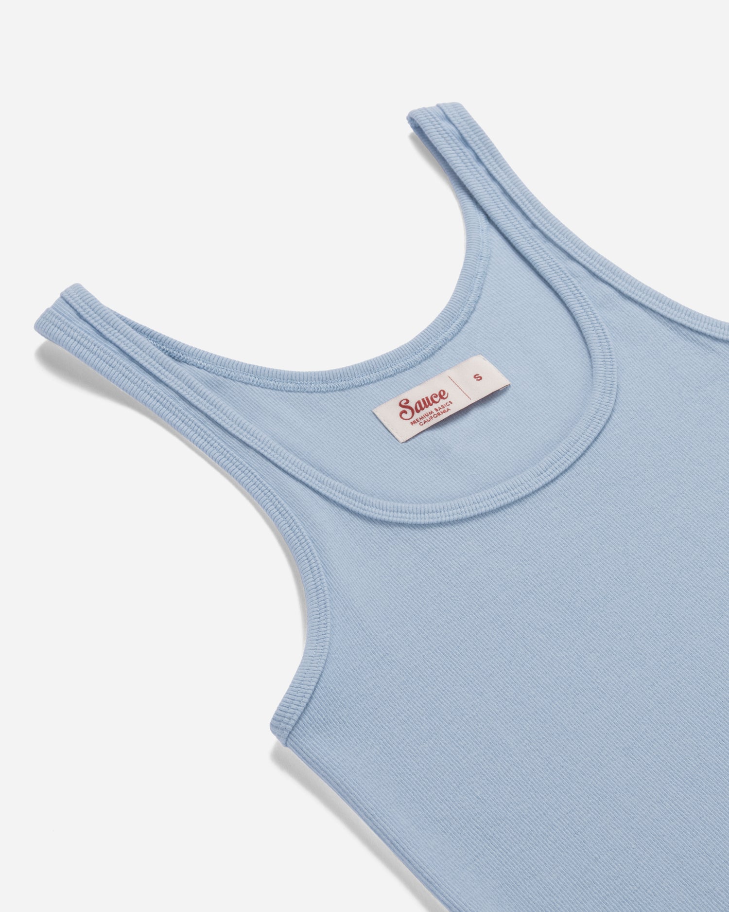 Light blue tank top with a brand label on a white background