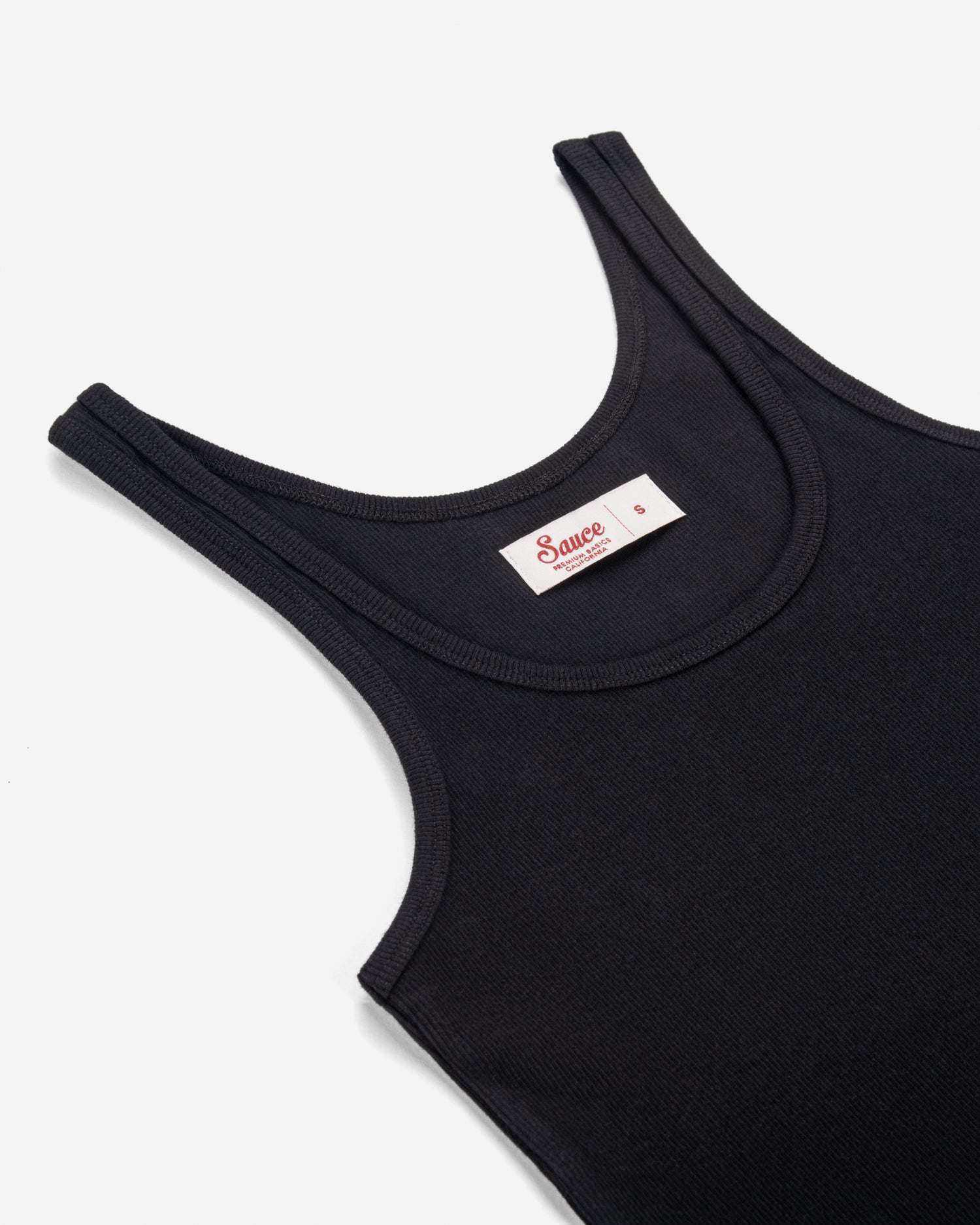 Black tank top with a brand label on a white background