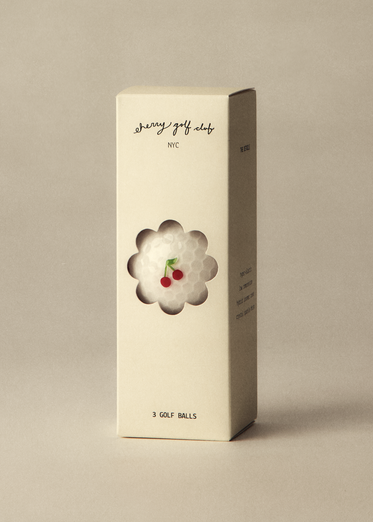 A tall cream-colored product box for Berry Golf Club WIC, featuring a die-cut window that reveals a white golf ball with two red cherries on top, set against a solid beige background.