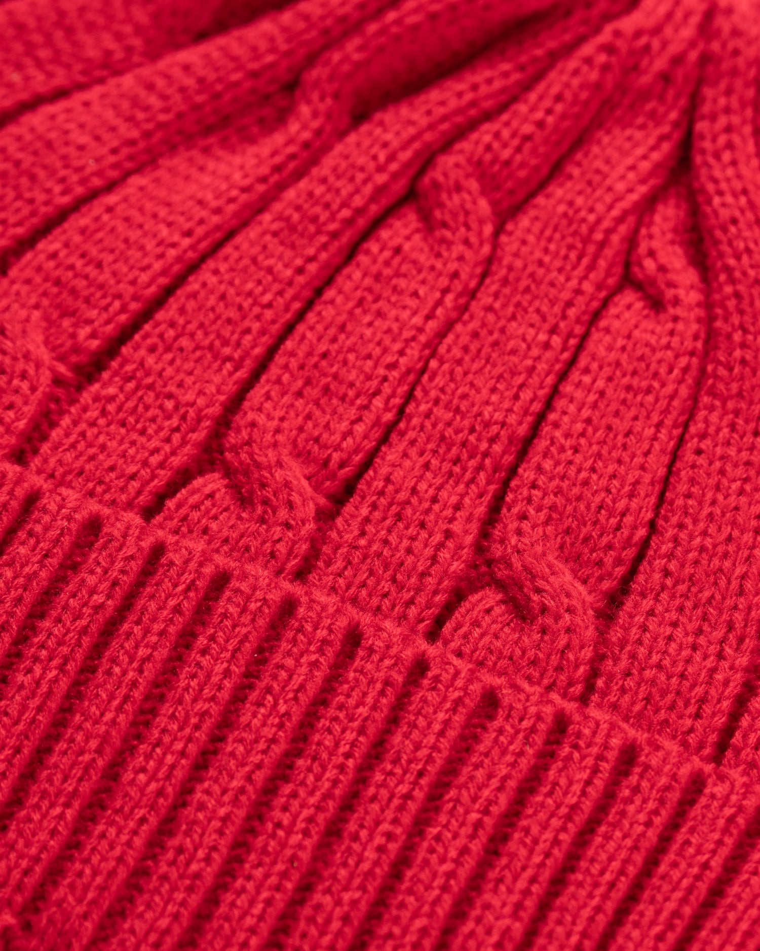 Close-up of a red knitted fabric with cable pattern