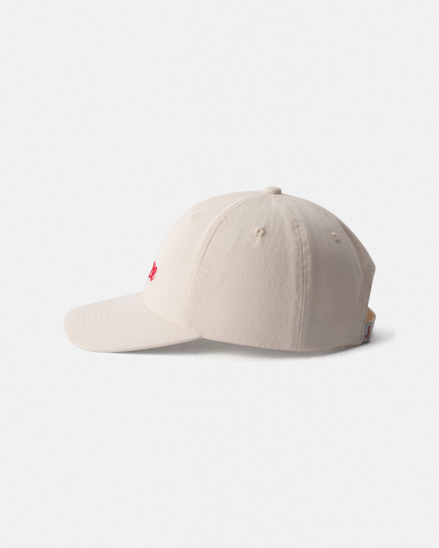 Beige cap with a small red logo on a light gray background