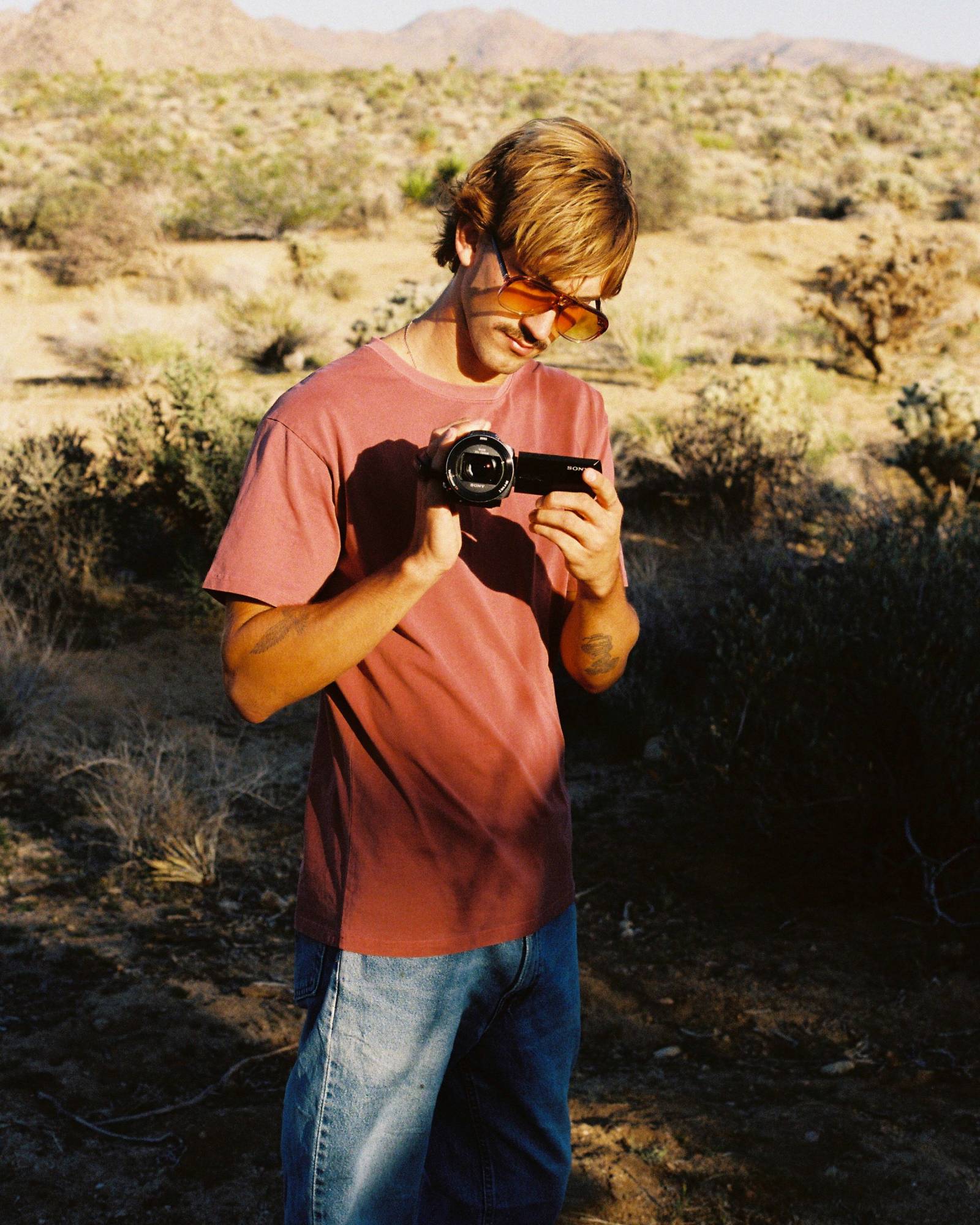 Person holding a camera in a desert landscape